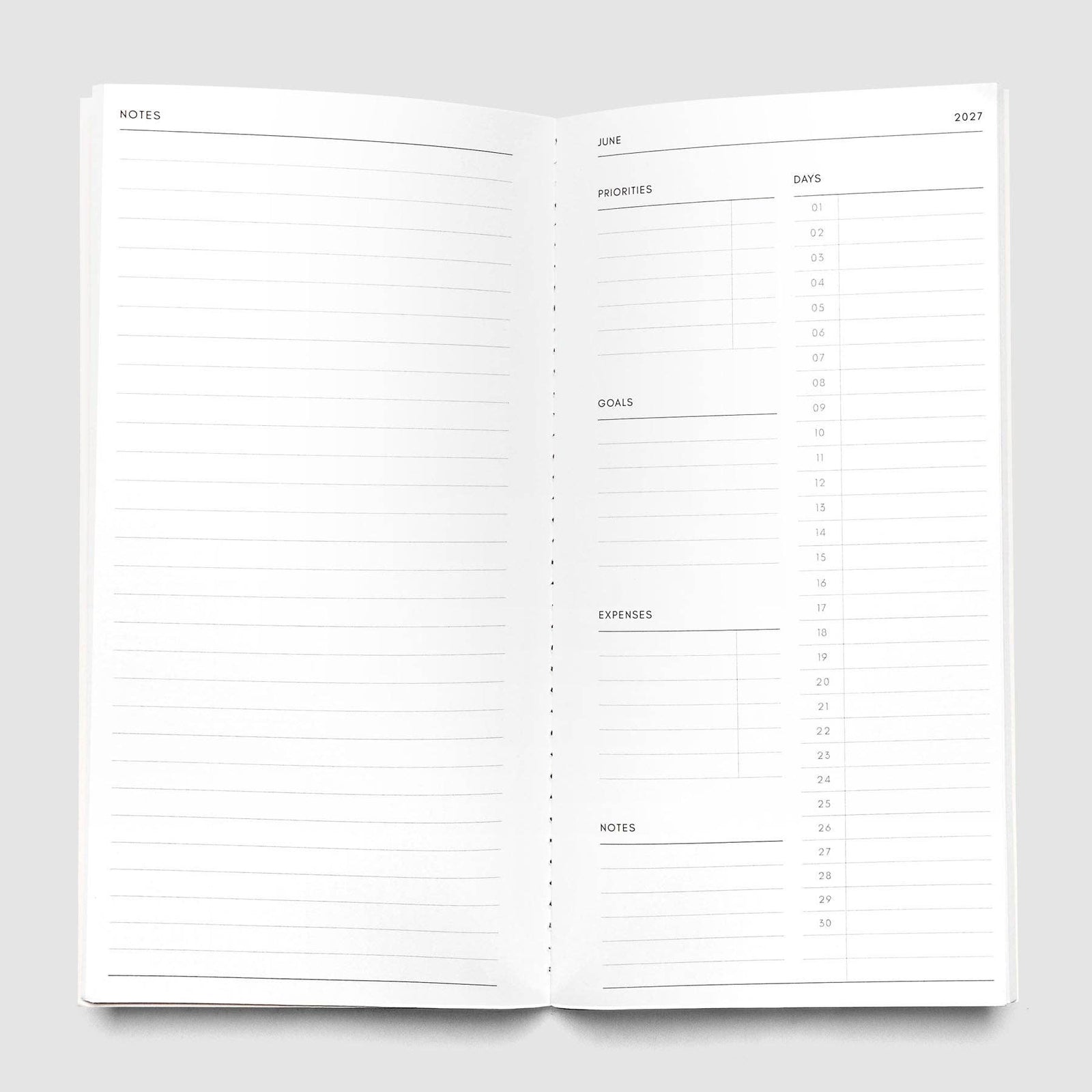 A minimalist off-white planner or journal with a glossy cover, shown vertically against a solid light gray background.