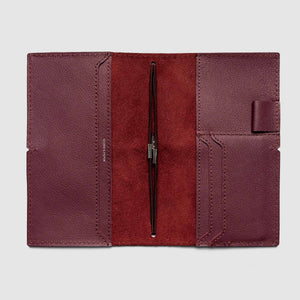 Folded leather wallet with a pen holder on a light gray background
