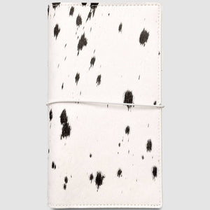 White notebook with black abstract pattern on a light gray background