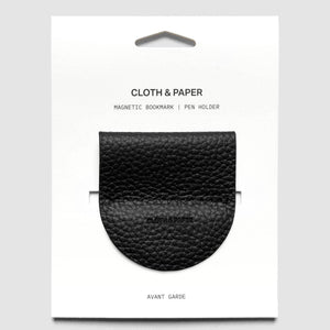 A black pebbled leather magnetic bookmark holder in its original white retail packaging, labeled 'CLOTH & PAPER'.