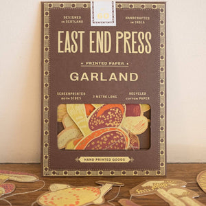 Packaging of East End Press Garland printed paper with decorative cutouts on a wooden surface.