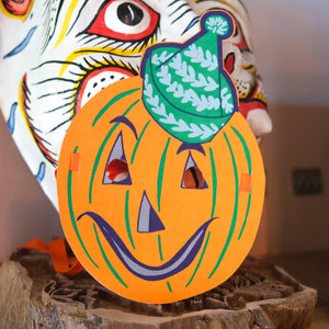 Colorful pumpkin decoration with a face on a wooden base