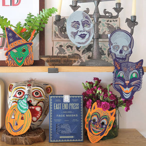 Decorative shelf with Halloween-themed masks and candles