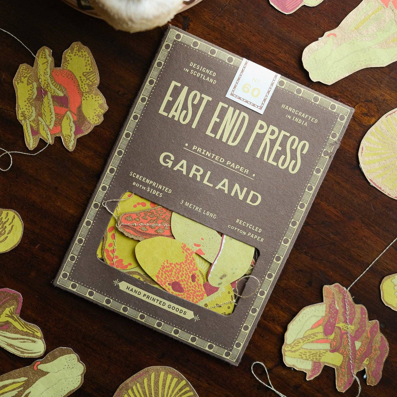 East End Press Garland packaging on a wooden surface with decorative cutouts.
