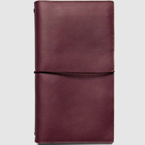 Maroon leather notebook on a light gray background